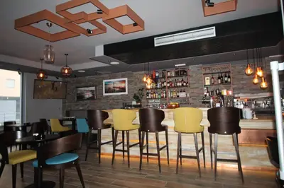 a restaurant with yellow chairs and a bar at Le Marc Guest house in Budva