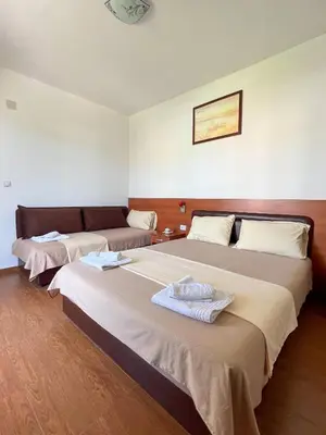 a room with two beds and a couch at Apartments Fat e Jet - Pool & Breakfast in Ulcinj