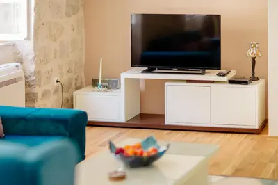 a living room with a tv and a bowl of fruit on a table at Old Town Museum Square Apartment in Kotor
