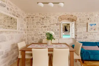 a dining room with a wooden table and chairs at Old Town Museum Square Apartment in Kotor