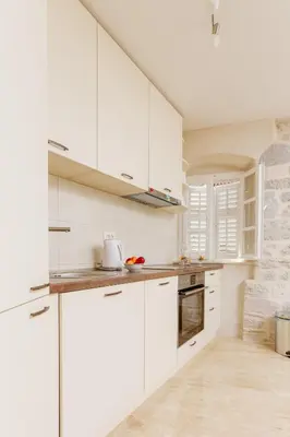 a white kitchen with white cabinets and appliances at Old Town Museum Square Apartment in Kotor