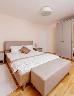 a white bedroom with a large bed and a cabinet at Old Town Museum Square Apartment in Kotor