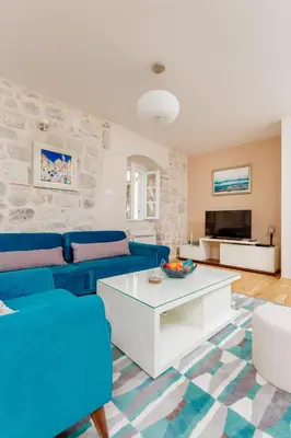 a living room with a blue couch and a table at Old Town Museum Square Apartment in Kotor