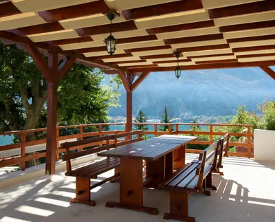 a wooden pavilion with a table and benches on a deck at Villa Mima in Kotor