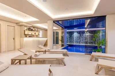 a living room with a pool and tables at Vujanović Apartments in Sveti Stefan