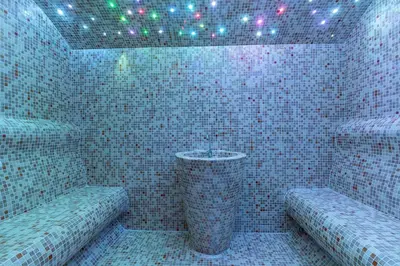 a tiled bathroom with a sink and two benches at Vujanović Apartments in Sveti Stefan