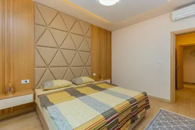 a bedroom with a bed and a large wall at Vujanović Apartments in Sveti Stefan