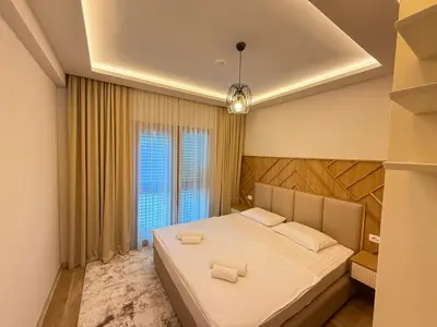 a bedroom with a large bed with two white towels at Vujanović Apartments in Sveti Stefan