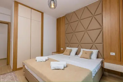 a bedroom with two beds with white sheets at Vujanović Apartments in Sveti Stefan