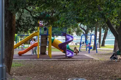a playground with a slide in a park at Apartman Kotor in Kotor