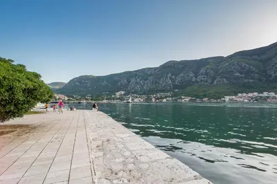 people walking on a pier next to a body of water at Apartman Kotor in Kotor