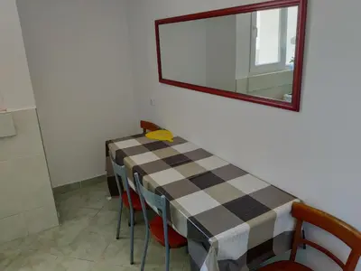 a room with a table with chairs and a mirror at Apartman La Siesta in Bar