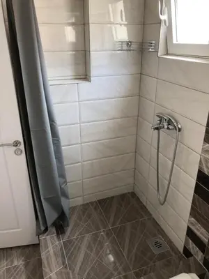 a shower with a hose in a bathroom at Three Palms Apartments Novakovic in Petrovac na Moru