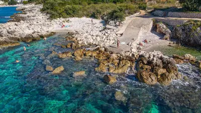an aerial view of a beach with people in the water at Apartments Limunada in Utjeha
