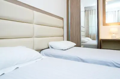 two beds in a hotel room with a mirror at Apartments Limunada in Utjeha