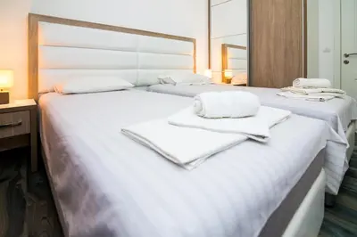a bedroom with two beds with towels on them at Apartments Limunada in Utjeha