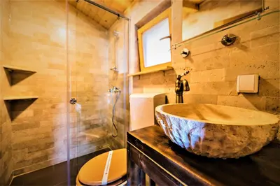 a bathroom with a large stone sink on a counter at Holiday Park Olive Tree in Ulcinj
