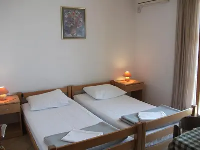 two beds in a room with two lamps on tables at Monterama Apartments in Sutomore