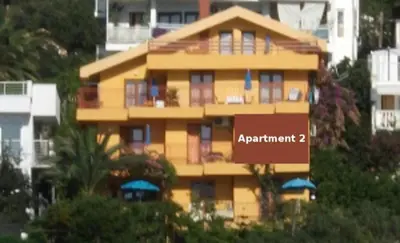 a yellow building with a sign that reads apartment at Monterama Apartments in Sutomore