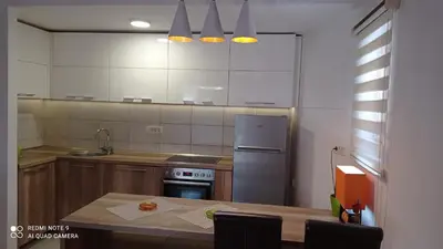 a kitchen with a stainless steel refrigerator and a table at Apartment Maja in Budva