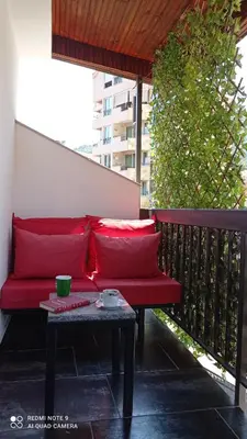 a red couch sitting on a balcony with a table at Apartment Maja in Budva
