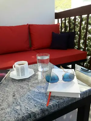 a table with sunglasses and a red couch at Apartment Maja in Budva