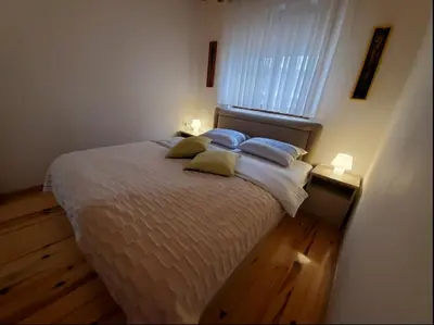 a bedroom with a bed with two pillows and a window at Apartment Maja in Budva