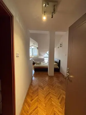 a hallway leading to a living room with a wooden floor at Apartment The Royal Pg in Podgorica