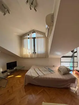 a bedroom with a bed and a desk and a window at Apartment The Royal Pg in Podgorica