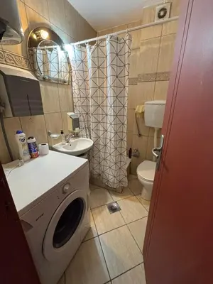 a bathroom with a washing machine and a sink at Apartment The Royal Pg in Podgorica