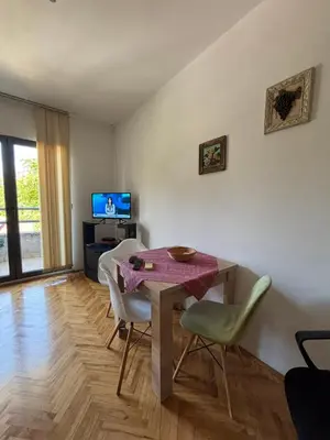 a living room with a table and chairs and a television at Apartment The Royal Pg in Podgorica