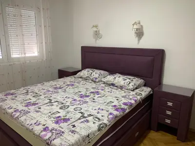 a bedroom with a bed with a purple comforter at Alex Apartment in Bar
