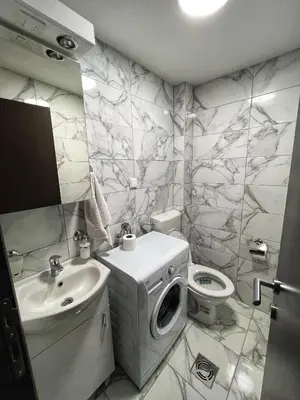 a bathroom with a sink and a washing machine at Alex Apartment in Bar