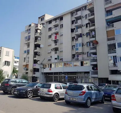 a parking lot with cars parked in front of a building at Alex Apartment in Bar