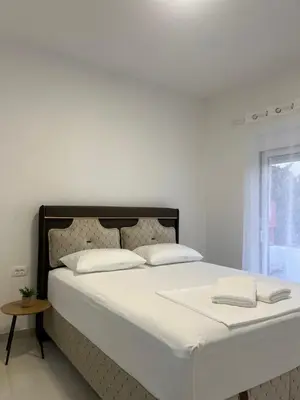 a white bed with two pillows on top of it at Guest House AGA in Ulcinj
