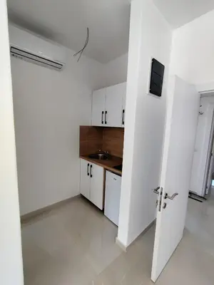 a white kitchen with white cabinets and a sink at Guest House AGA in Ulcinj