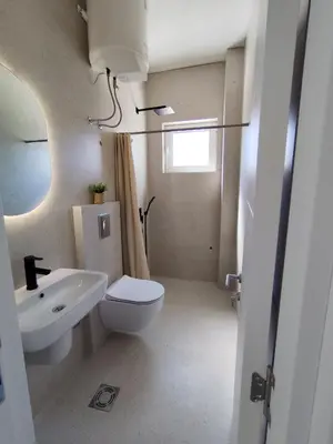 a bathroom with a white toilet and a sink at Guest House AGA in Ulcinj