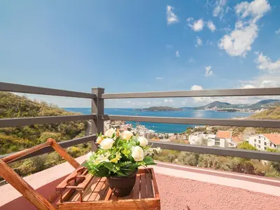 a table with a flower arrangement on a balcony at Apartments Princess View in Sveti Stefan