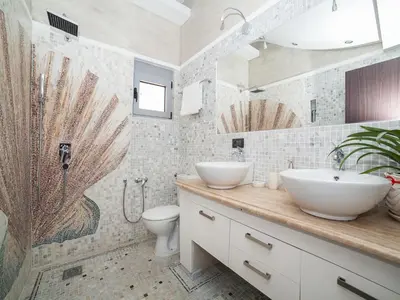 a bathroom with two sinks and a shower and a toilet at Apartments Princess View in Sveti Stefan