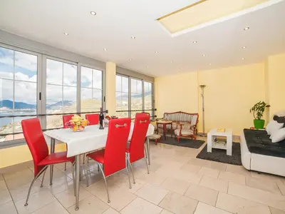 a living room with a table and red chairs at Apartments Princess View in Sveti Stefan