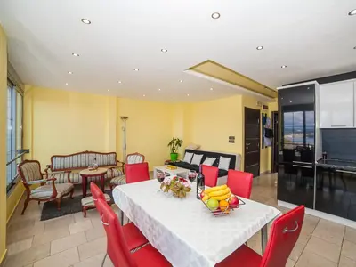 a dining room with a table and red chairs at Apartments Princess View in Sveti Stefan