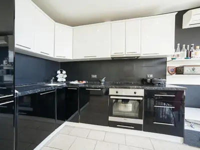 a kitchen with white cabinets and black counter tops at Apartments Princess View in Sveti Stefan