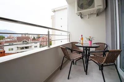 a balcony with a table and chairs and a window at Milara Apartments in Budva