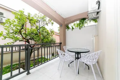 a patio with a table and chairs on a balcony at Milara Apartments in Budva