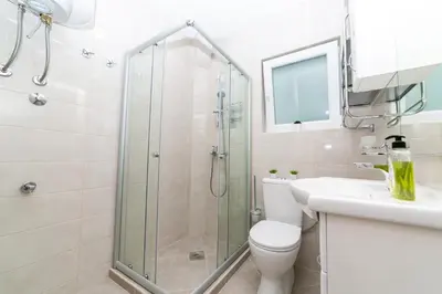 a bathroom with a shower and a toilet and a sink at Milara Apartments in Budva