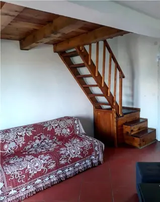 a living room with a red couch and a staircase at Draga`s rooms in Virpazar
