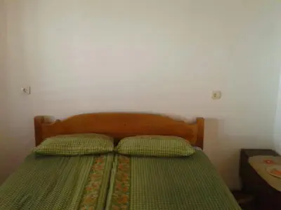 a bedroom with a green bed with two pillows at Draga`s rooms in Virpazar
