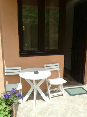 a white table and two chairs on a patio at Draga`s rooms in Virpazar