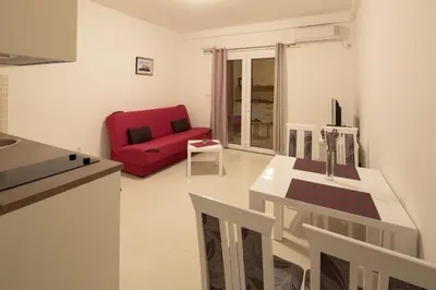 a living room with a red couch and a table at Apartments Raskovic in Radanovići