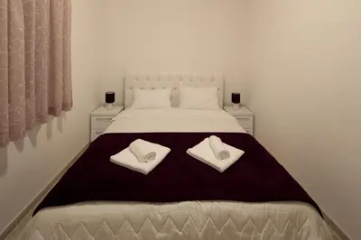a white bed with two white pillows on it at Apartments Raskovic in Radanovići